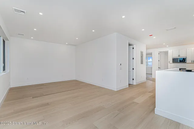 a view of kitchen with refrigerator and white cabinets