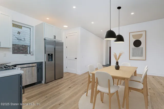 a kitchen with stainless steel appliances granite countertop a kitchen island hardwood floor and a sink