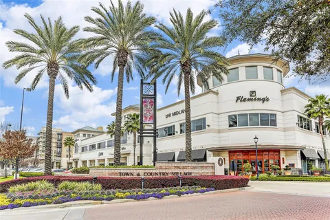 a front view of multi story residential apartment building with yard and sign board