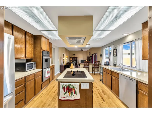 a kitchen with stainless steel appliances kitchen island granite countertop a stove and a sink