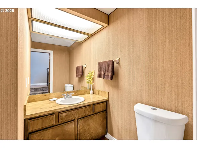 a bathroom with a sink a toilet and mirror