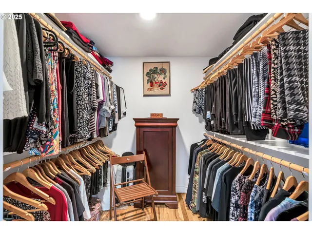 a view of walk in closet with clothes and shoes