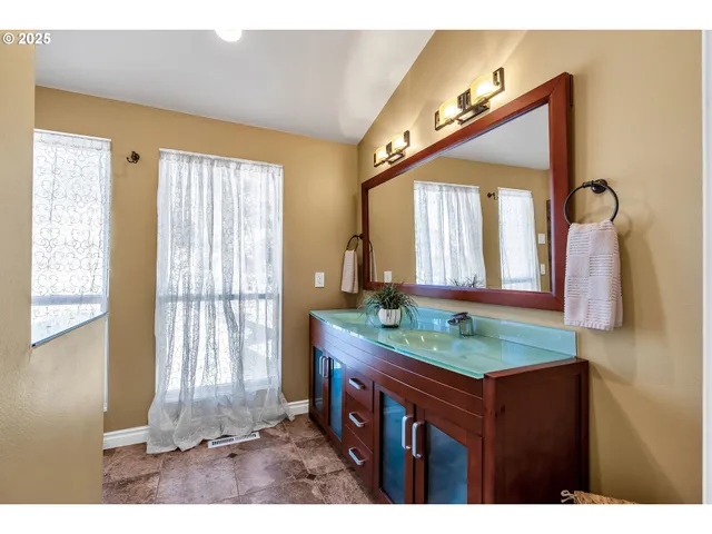 a bathroom with a granite countertop sink and a mirror