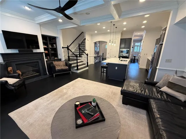 a living room with stainless steel appliances furniture and a flat screen tv