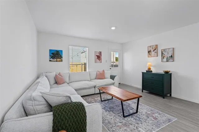 a living room with furniture a rug and a window