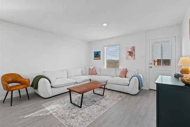 a living room with furniture a rug and a window