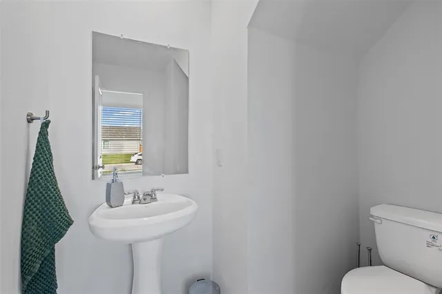 a bathroom with a sink a toilet and mirror