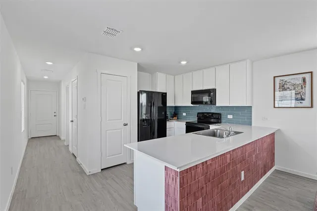 a kitchen with a refrigerator a sink dishwasher with a oven and cabinets
