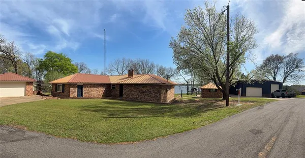 a white house with a big yard and large trees