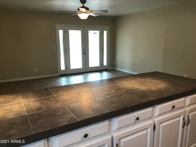 a view of a livingroom with a chandelier fan and window