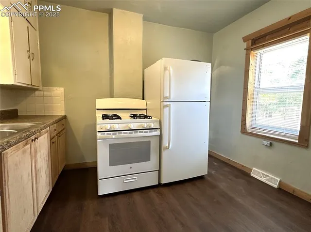 a kitchen with a white stove top oven and refrigerator