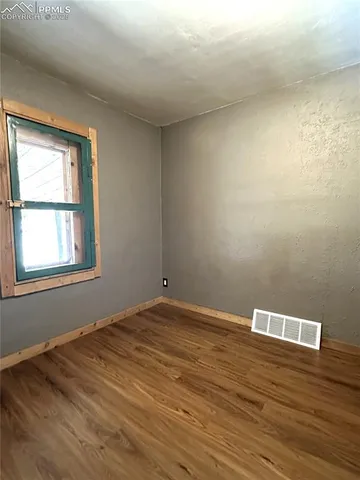 a view of empty room with wooden floor