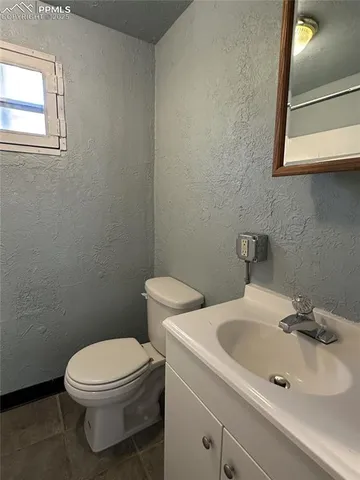 a bathroom with a sink a toilet and mirror