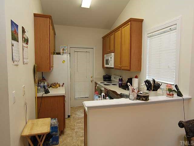 7024 Sandy Forks Road, Unit 301 Raleigh, NC 27615 - Photo 5 of 11 a kitchen with a sink and a refrigerator