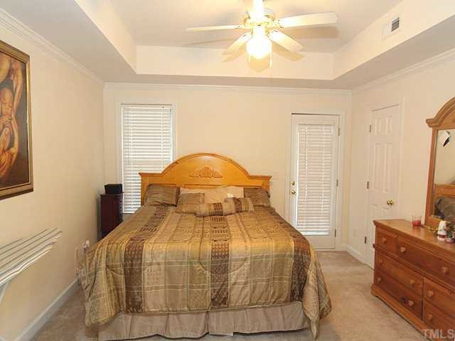 7024 Sandy Forks Road, Unit 301 Raleigh, NC 27615 - Photo 6 of 11 a bedroom with a bed and a chandelier