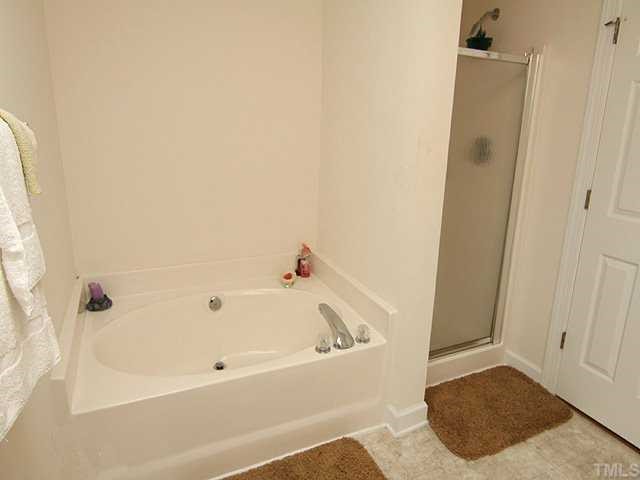 7024 Sandy Forks Road, Unit 301 Raleigh, NC 27615 - Photo 7 of 11 a bathroom with a bathtub and a shower