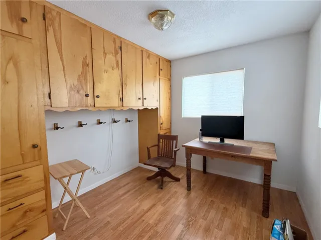 a view of a workspace with furniture and a window