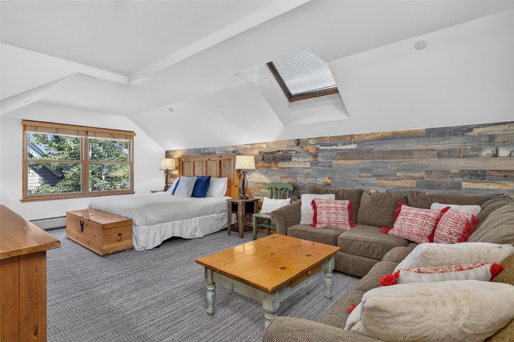 129 River Run Road, Unit 8051 Keystone, CO 80435 - Photo 19 of 50 Attic living area featuring a wood-panel accent wall, sloped ceilings, a skylight, and a double window