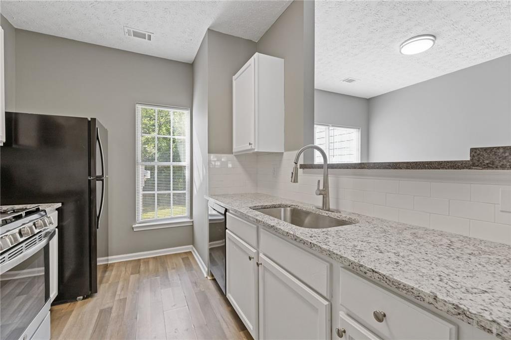2566 Walden Lake Drive Decatur, GA 30035 - Photo 11 of 30 a kitchen with stainless steel appliances granite countertop a sink stove and refrigerator