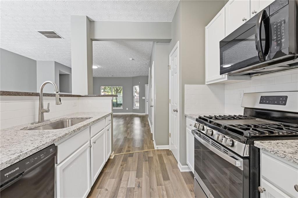 2566 Walden Lake Drive Decatur, GA 30035 - Photo 13 of 30 a kitchen with granite countertop cabinets stainless steel appliances and a sink