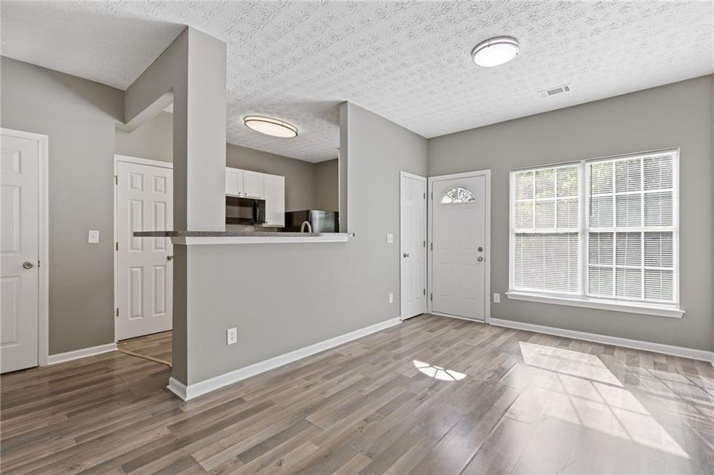 2566 Walden Lake Drive Decatur, GA 30035 - Photo 9 of 30 an empty room with wooden floor and windows