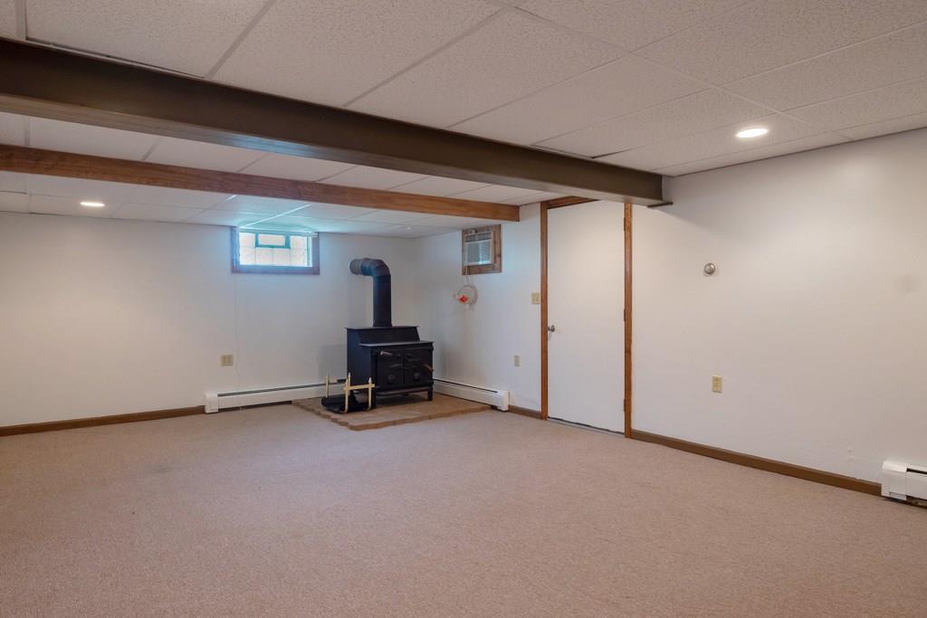 572 Harmony Road New Brighton, PA 15066 - Photo 17 of 24 Plenty of space for everyone in this family room that features a wood burning stove.