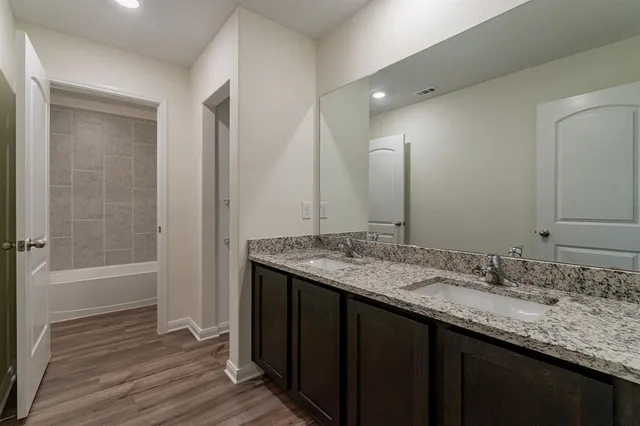 a bathroom with a granite countertop sink and a mirror