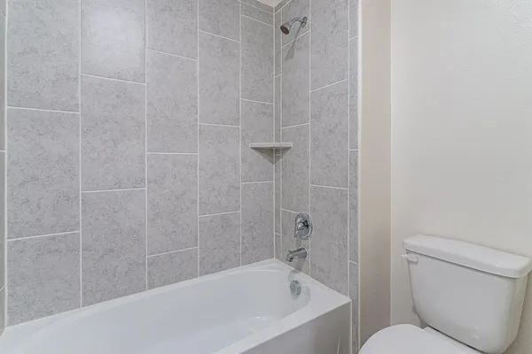 a white bath tub sitting next to a toilet
