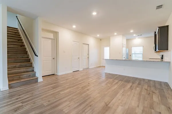 a view of a kitchen with wooden floor and stairs
