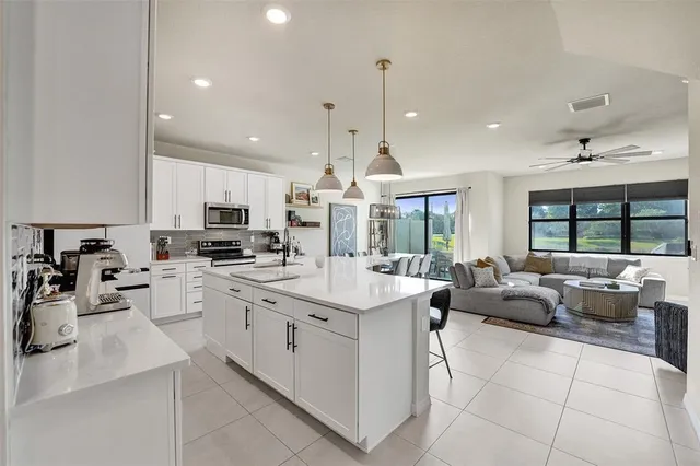a large kitchen with kitchen island a dining table chairs and a wooden floor