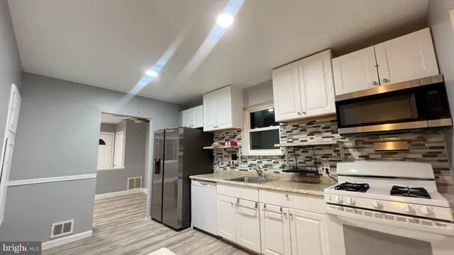 a kitchen with stainless steel appliances a refrigerator a stove a microwave and cabinets