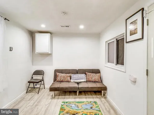 a living room with furniture and a painting on the wall