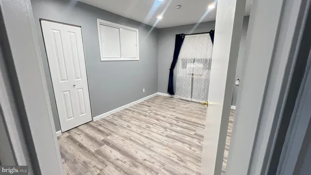 a view of a hallway with wooden floor and entryway