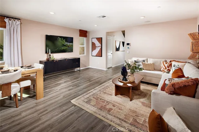 a living room with furniture a flat screen tv and a large window