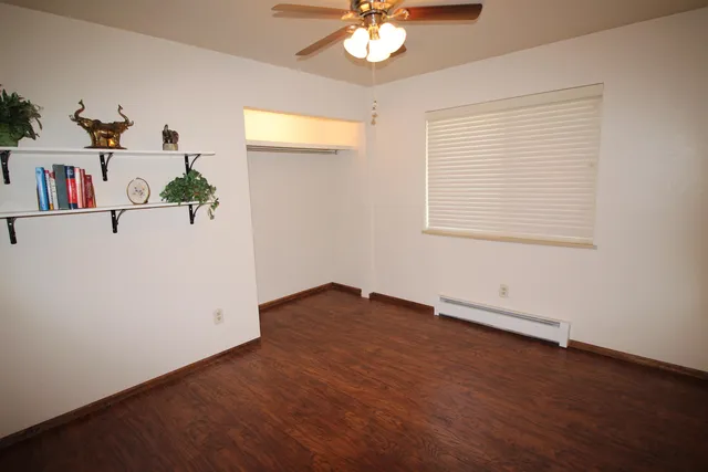 an empty room with a window and a ceiling fan