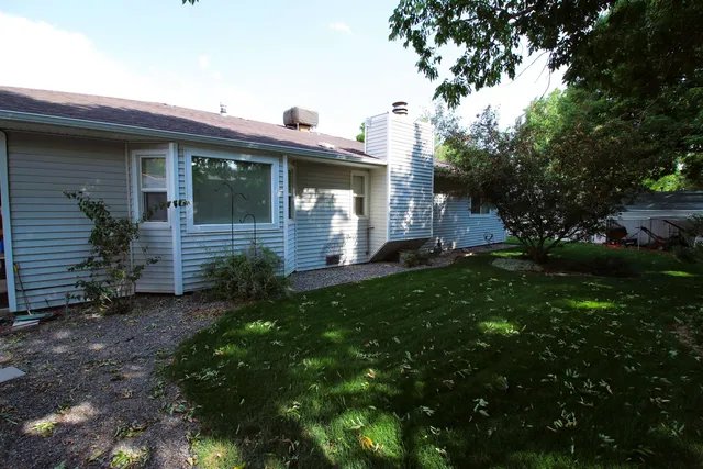 a backyard of a house with table and chairs