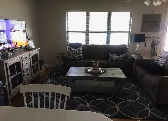 a living room with furniture a large window and a flat screen tv