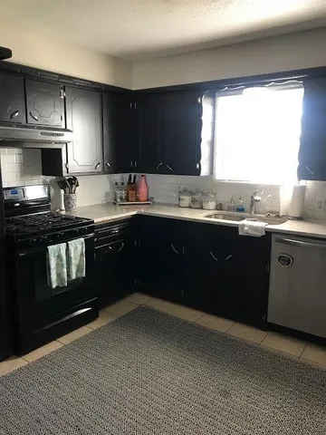 a kitchen with a sink stove top oven and cabinets