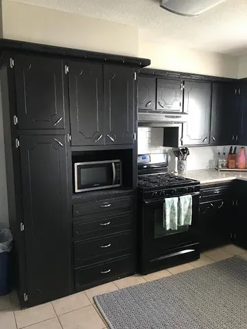 a kitchen with a refrigerator stove and cabinets
