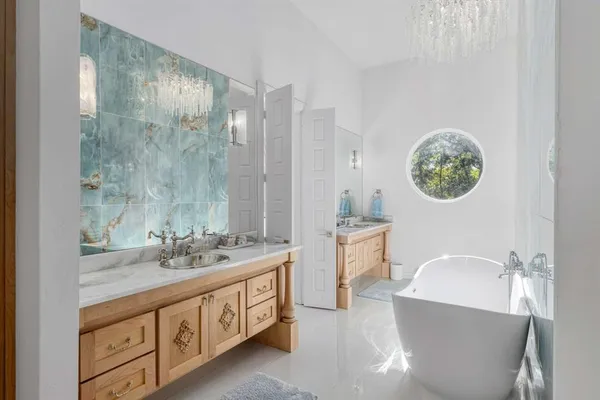 a spacious bathroom with a double vanity sink a mirror a bathtub and a shower