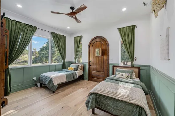 a bedroom with a bed a mirror and window