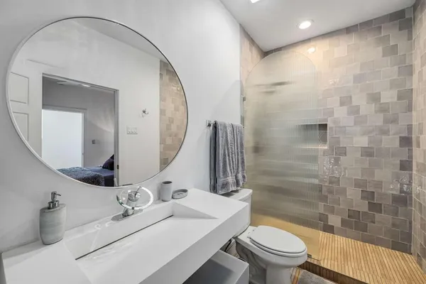 a bathroom with a sink a toilet and shower
