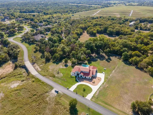 an aerial view of a house with a yard and lake view