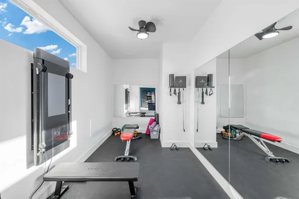 a living room with furniture kitchen view and a large window