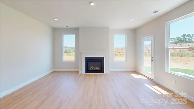 an empty room with windows and a fireplace