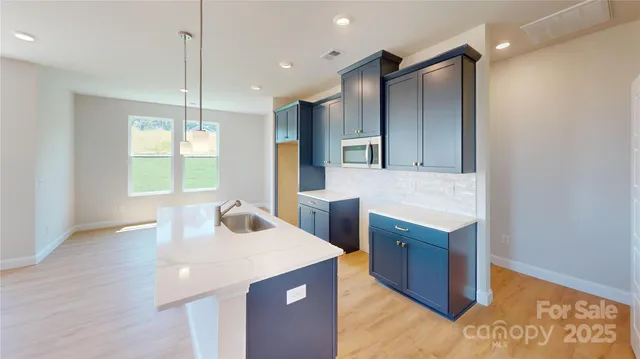 a kitchen with kitchen island sink stove and refrigerator