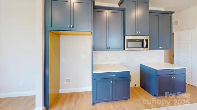 a kitchen with stainless steel appliances granite countertop a refrigerator and a microwave oven