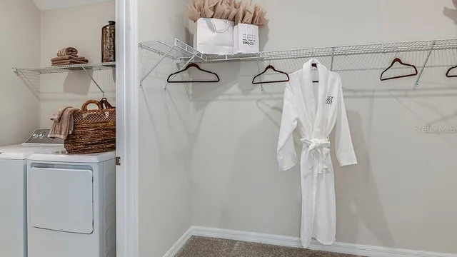 a view of walk in closet with clothes