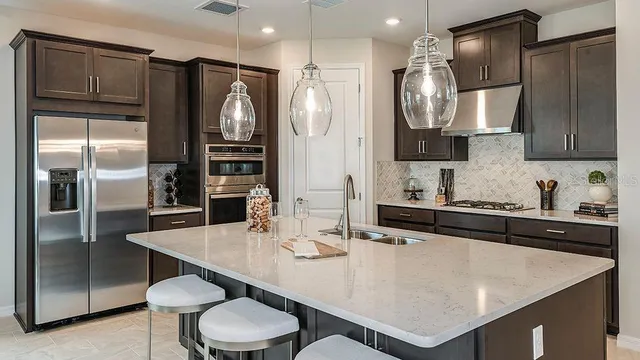 a kitchen with stainless steel appliances a sink stove and refrigerator