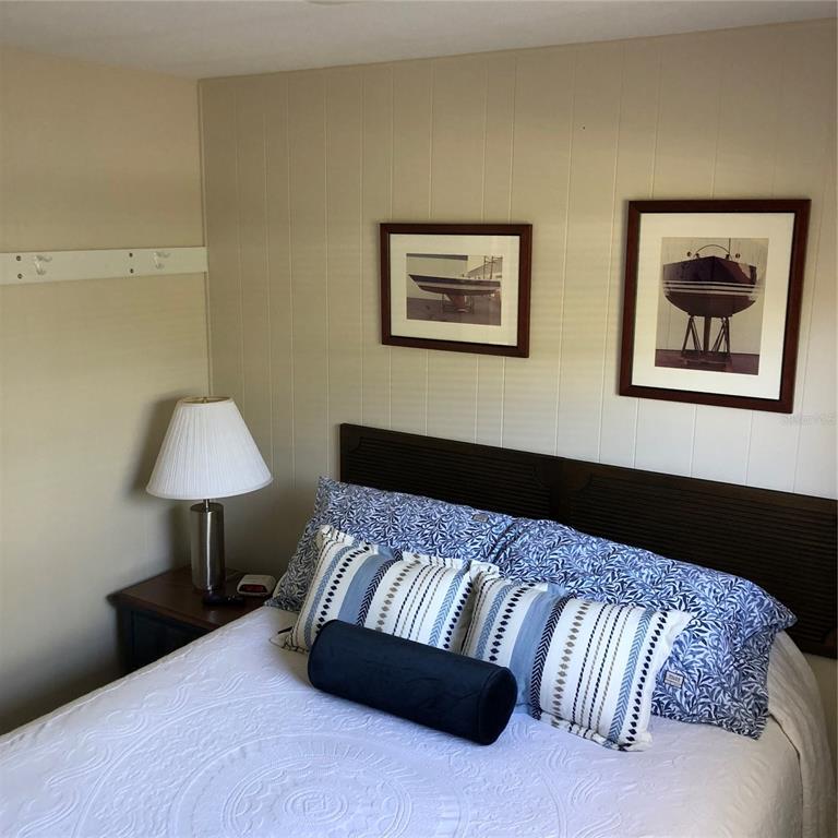 24437 Harbor View Road, Unit 12 Port Charlotte, FL 33980 - Photo 11 of 36 a bedroom with a bed and a lamp